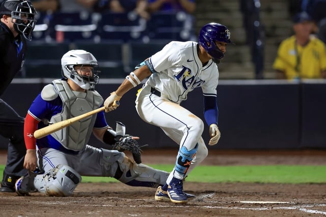 The Rays' Chandler Simpson follows through on a run-scoring single in front of Toronto catcher Alejandro Kirk during the seventh inning on Wednesday in Tampa.  (AP Photo/Mike Carlson)