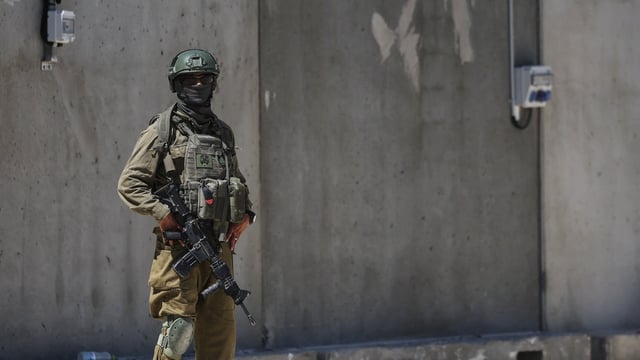 FILE: An Israeli soldier stands by during preparations at a distribution center in the southern Gaza Strip.