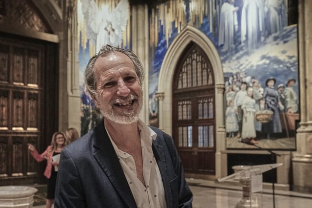 Artist Adam Cvijanovic poses for a photo during the media preview his 25-foot-high mural, the largest artwork ever commissioned for St. Patrick's Cathedral, in New York, Thursday, Sept. 18, 2025. (AP Photo/Richard Drew)