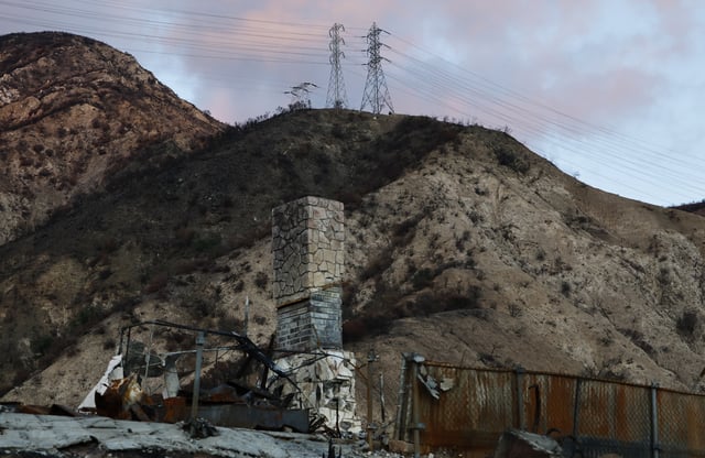 ALTADENA, CALIFORNIA – MARCH 11: SoCal Edison transmission towers (TOP) stand above a home destroyed in the Eaton Fire on March 11, 2025 in Altadena, California. Los Angeles County filed a lawsuit last week alleging that Southern California Edison’s electrical equipment caused the Eaton Fire which left 17 people dead and 9,400 buildings destroyed. (Photo by Mario Tama/Getty Images)