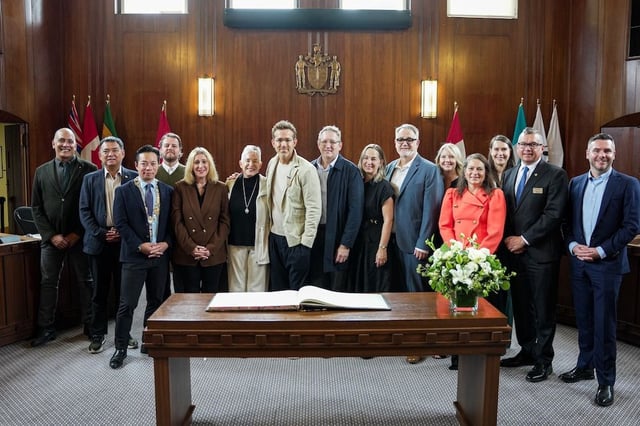  Ryan Reynolds, centre, stands beside his mom Tammy, left, along with Mayor Ken Sim and Vancouver City Council members at Vancouver City Hall on Thursday.