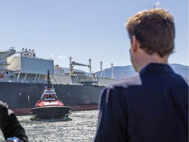 Premier David Eby watches as a LNG carrier maneuvers with the help of a tugboat in Kitimat. 