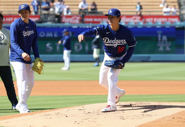 LOS ANGELES, CALIFORNIA - AUGUST 9: Pitcher Yoshinobu Yamamoto #18 of the Los Angeles Dodgers practices fielding with pitcher Roki Sasaki #11 looking on before a baseball game against the Toronto Blue Jays at Dodger Stadium on August 9, 2025 in Los Angeles, California.