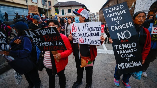 Personas sostienen carteles durante una marcha contra el Gobierno del presidente de Ecuador, Daniel Noboa, en Quito (Ecuador).