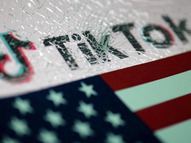 FILE PHOTO: The U.S. flag and the TikTok logo seen through broken glass are seen in this illustration taken January 16, 2025. REUTERS/Dado Ruvic/Illustration/File Photo