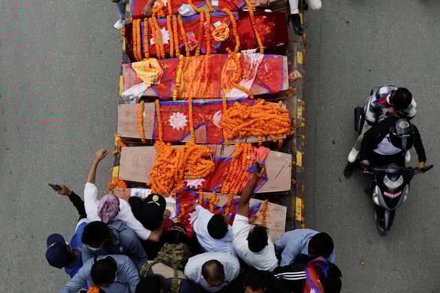 People stand next to the coffins with the bodies of people, who died in last week's anti-corruption protests that toppled the government, on a vehicle during a tribute rally in Kathmandu, Nepal, September 16, 2025. REUTERS/Navesh Chitrakar