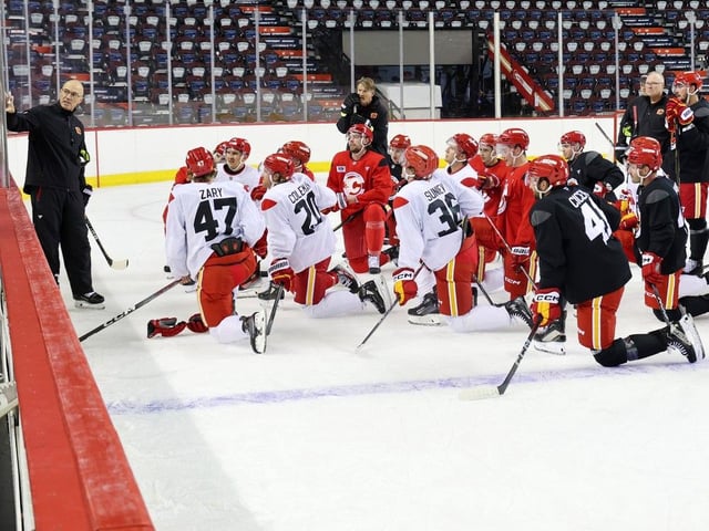  Flames head coach Ryan Huska goes over drills with players during training camp on Thursday.