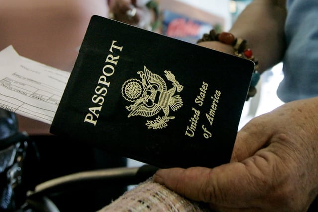 Travelers take out their passports before checking in at San Diego International Airport.