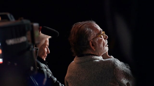 A man sits and looks.