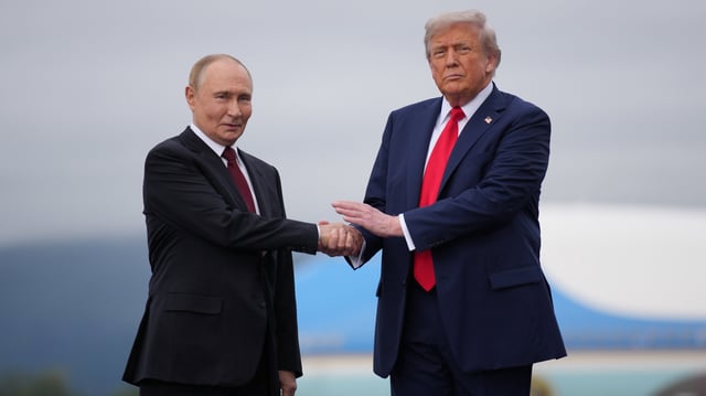 U.S. President Donald Trump (R) greets Russian President Vladimir Putin as he arrives at Joint Base Elmendorf-Richardson on August 15, 2025 in Anchorage, Alaska.