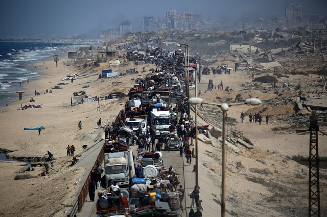 Palestinians from Gaza City move southwards with their belongings, on the coastal road near the Nuseirat refugee camp in the central Gaza Strip, on Sept. 19, 2025. 