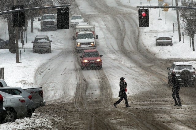 Pedestrians and cars can be seen contending with heavy snow on February 5, 2014, in Burlington, Vermont.
