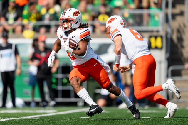 Quarterback Zane Flores #6 of the Oklahoma State Cowboys hands off the ball to running back Freddie Brock IV #25 during the second half of the game at Autzen Stadium on September 6, 2025 in Eugene, Oregon.