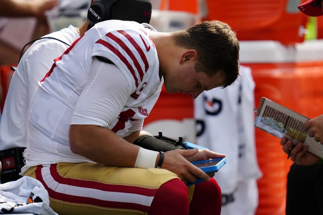 San Francisco 49ers quarterback Brock Purdy looks at a Microsoft Surface tablet during the game against the Seahawks on Sunday, Sept. 7, 2025 in Seattle.