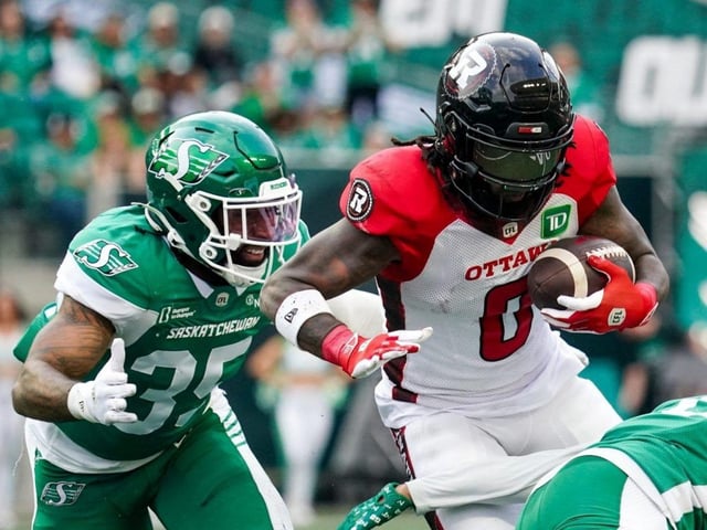 Ottawa Redblacks receiver Bralon Addison evades a Saskatchewan Roughriders defender during the first half of CFL football action in Regina on June 5, 2025. 