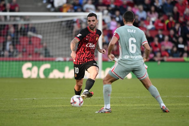 Sergi Darder intenta centrar el balón a un compañero ante la presencia de Koke, centrocampista del Atlético de Madrid.