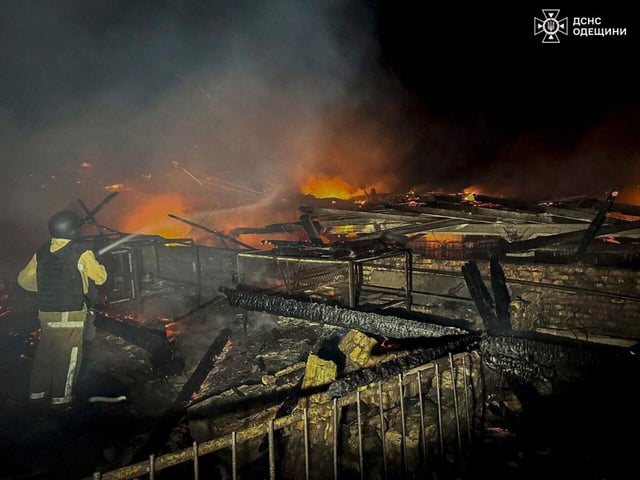 Un trabajador de rescate apaga el incendio de un granero destruido por un ataque ruso en la región de Odesa.