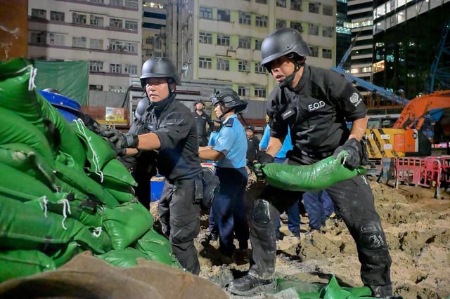Efectivos policiales de Hong Kong, dirigidos por la unidad de eliminación de municiones, trabajando para fragmentar el artefacto y provocar una explosión controlada de una bomba de la Segunda Guerra Mundial