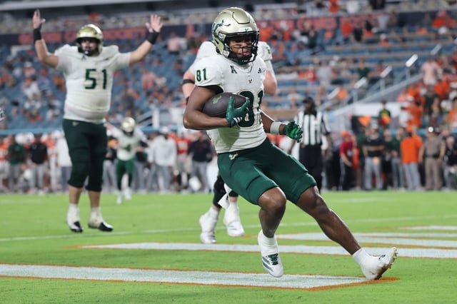 Wide receiver Christian Neptune #81 of the South Florida Bulls rushes for a touchdown against the Miami Hurricanes during the second half at Hard Rock Stadium on September 13, 2025 in Miami Gardens, Florida.