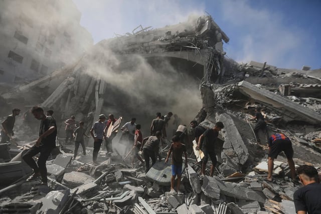 Palestinians search for wood on Sunday to sell or use for cooking amid the rubble of a building destroyed in an Israeli military strike in Gaza City. Photo: AP