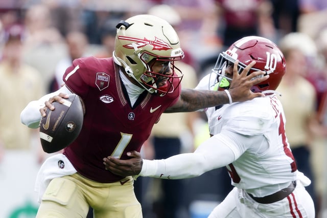Tommy Castellanos #1 of the Florida State Seminoles stiff arms Justin Jefferson #10 of the Alabama Crimson Tide as he scrambles during the third quarter of a football game at Doak Campbell Stadium on August 30, 2025 in Tallahassee, Florida.