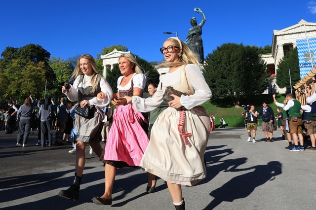 Oktoberfestbesucher stürmen bei strahlendem Sonnenschein auf die Festwiese. Die Hitze macht vielen Besuchern zu schaffen.