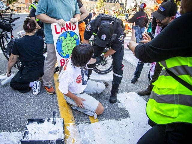 Protesters clashed with Ottawa police multiple times on Wellington Street as officers attempted to clear the roadway and stop demonstrators from painting the road surface.