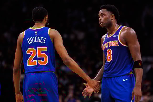 Mikal Bridges #25 and OG Anunoby #8 of the New York Knicks react during first half of their NBA game against the Toronto Raptors at Scotiabank Arena on December 9, 2024 in Toronto, Canada.