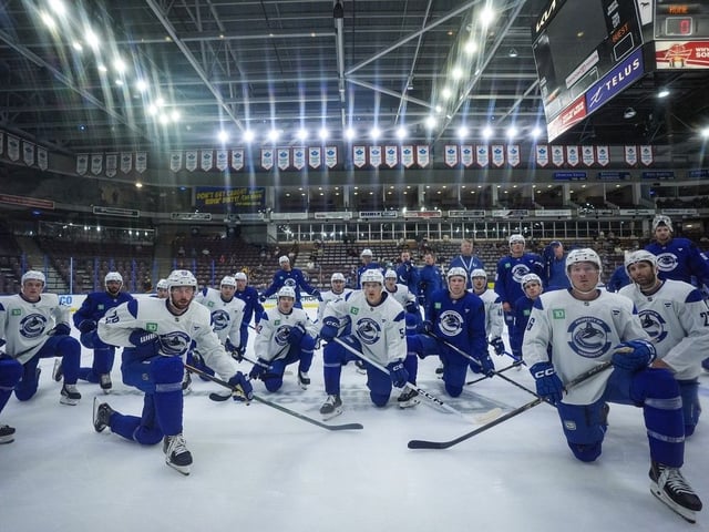  Vancouver Canucks players, including Marcus Pettersson (29), Aatu Raty (54), Brock Boeser (6) and Derek Forbort (27) listen to instructions for a drill during the opening day of the NHL hockey team’s training camp, in Penticton, on Thursday, September 18, 2025.