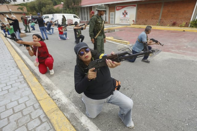 Des membres des conseils communautaires et civils s'exercent avec des fusils lors d'une formation militaire à Fort Tiuna, Caracas, le 20 septembre 2025