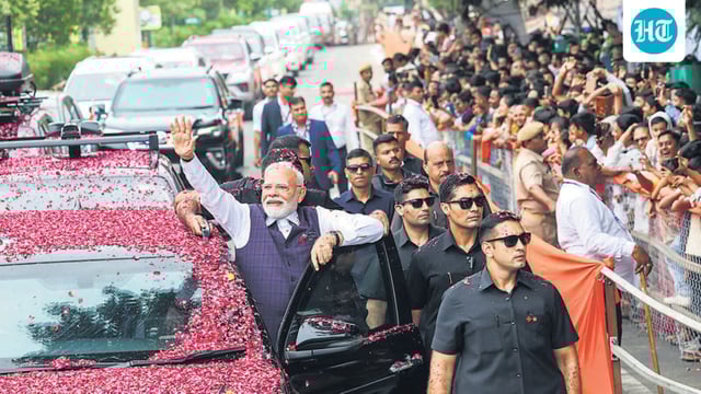 Prime Minister Narendra Modi waves to the gathering during a roadshow in Bhavnagar, Gujarat, on Saturday. (ANI)