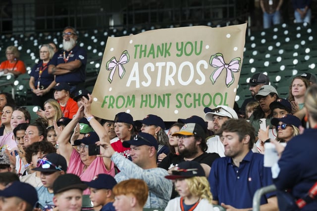 Astros fans from Central Texas, including Hunt ISD, cheer after team owner Jim Crane, players and coaches visit with them before Saturday's game at Daikin Park. Crane and the Astros Foundation announced a $2.5 million commitment to rebuild and maintain the Ingram Little League Ballpark in Ingram, which was impacted by the July 4th floods in the Hill Country.