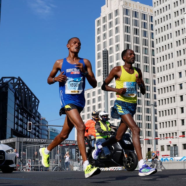 Ethiopia's Guye Adola (R) competes to win ahead of Kenya's Bethwel Yegon (L) during the Berlin Marathon on September 26, 2021 in Berlin. 