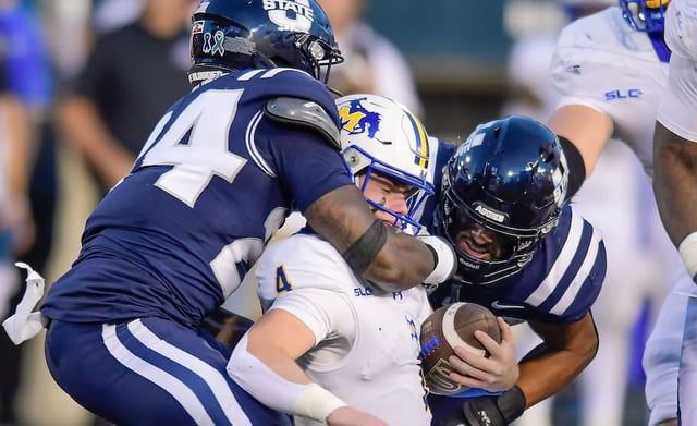 Utah State Aggies linebacker William Holmes (24) sacks McNeese State quarterback Jake Strong (4) as linebacker John Miller helps defend in the first half Saturday, Sept. 20, 2025, in Logan.