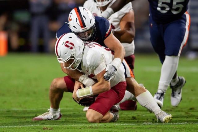 Virginia defensive lineman Daniel Rickert, top, sacks Stanford quarterback Ben Gulbranson, bottom, during the first half of an NCAA college football game Saturday, Sept. 20, 2025, in Charlottesville, Va. (AP Photo/Mike Caudill)