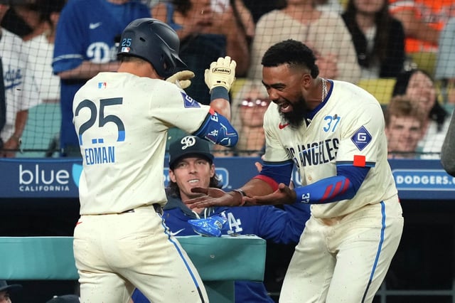 The Los Angeles Dodgers’ Tommy Edman is congratulated by Teoscar Hernández after hitting a solo home run during the fifth inning of Saturday’s game against the San Francisco Giants in Los Angeles. 
