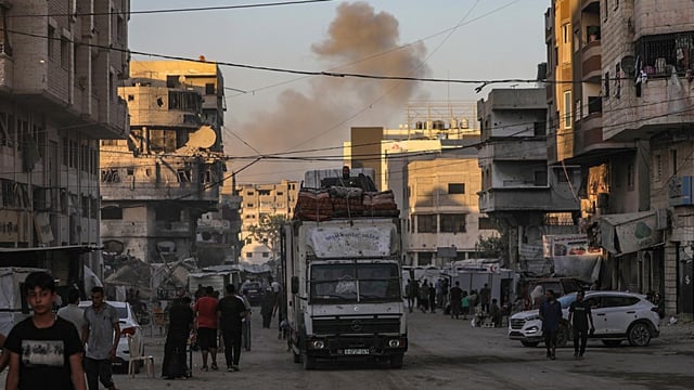 Palestinos desplazados internos evacúan una zona atacada por un ataque aéreo durante una operación militar israelí en la ciudad de Gaza.