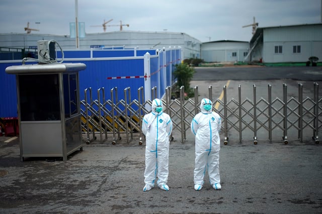 Workers in protective suits are seen at the Leishenshan Hospital, a makeshift hospital for treating patients with the coronavirus disease (COVID-19), in Wuhan, Hubei province, China April 11, 2020. REUTERS/Aly Song/File Photo