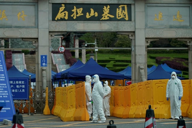 People wearing protective suits are seen in Biandanshan cemetery in Wuhan, Hubei province, the epicenter of China's coronavirus disease (COVID-19) outbreak, April 1, 2020. REUTERS/Aly Song/File Photo