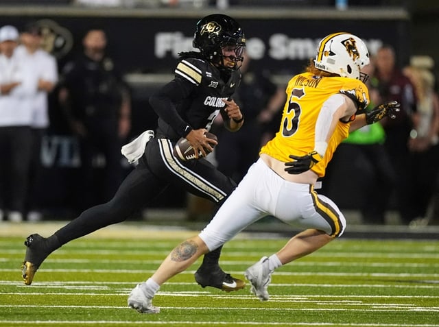 Colorado quarterback Kaidon Salter, left, runs around the corner for a short gain with Wyoming defensive end Brayden Wilson, right, in pursuit in the first half of an NCAA college football game Saturday, Sept. 20, 2025, in Boulder, Colo. (AP Photo/David Zalubowski)