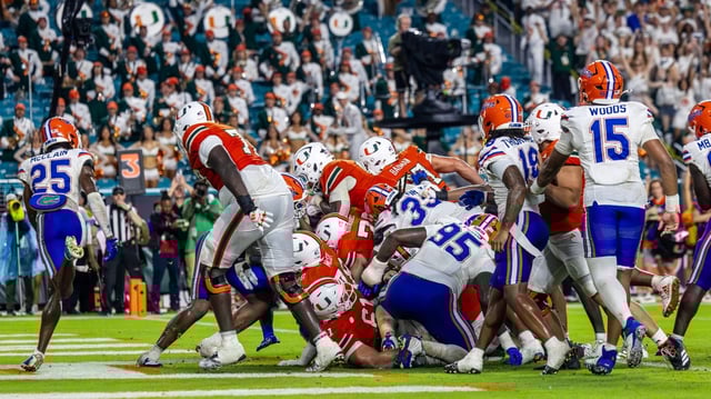 Miami Hurricanes running back Marty Brown diving over the visiting Florida Gators defense to score a touchdown at Hard Rock Stadium on Saturday. (Keira Arimenta/Contributor)