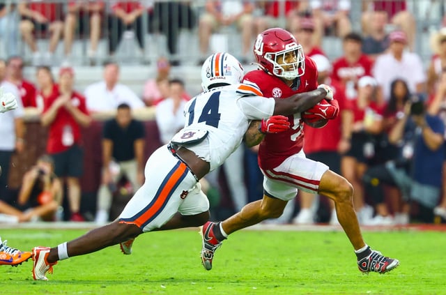 Sep 20, 2025; Norman, Oklahoma, USA;  Oklahoma Sooners wide receiver Isaiah Sategna III (5) runs with the ball as Auburn Tigers cornerback Rayshawn Pleasant (14) defends during the second half at Gaylord Family-Oklahoma Memorial Stadium. Mandatory Credit: Kevin Jairaj-Imagn Images