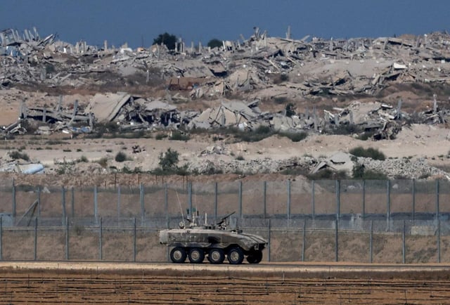 Un véhicule de transport de troupes blindé israélien (APC) manœuvre près de la frontière Israël-Gaza, vu d’Israël, le 19 septembre 2025.