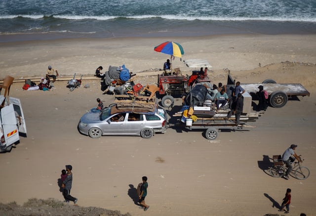 Displaced Palestinians, fleeing northern Gaza due to an Israeli military operation, move southward, hauling personal belongings along the shore, after Israeli forces ordered residents of Gaza City to evacuate to the south, in the central Gaza Strip, September 21, 2025. REUTERS/Mahmoud Issa