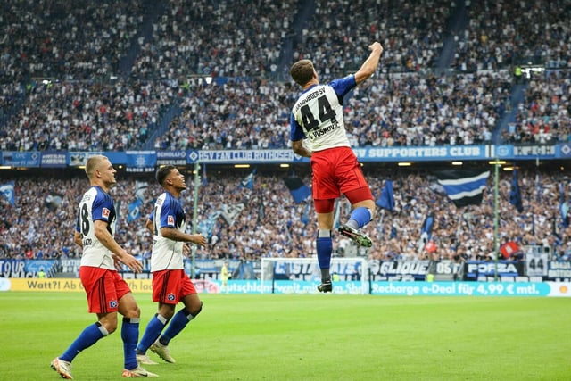 Ein Hamburger Spieler spingt in die Luft und reckt seinen rechten Arm jubelnd in die Höhe. Zwei Mitspieler stehen nebendran.