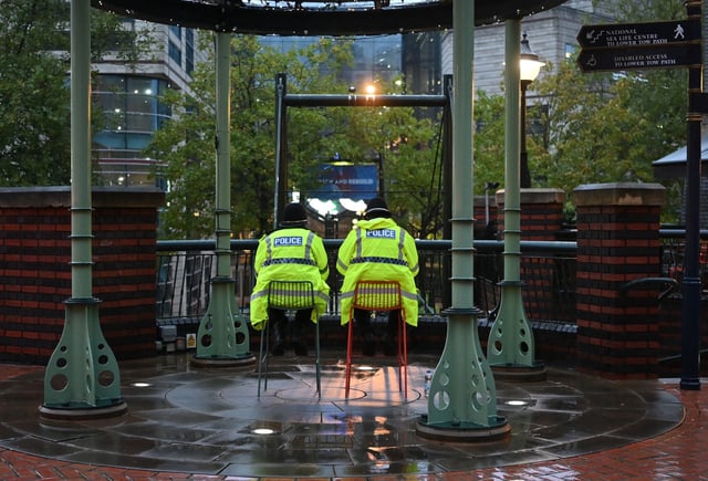 West Midlands Police officers shelter from the rain while on duty outside the entrance to the annual Conservative Party Conference in Birmingham, England, on September 30, 2024.