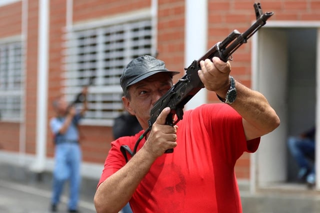 Un miembro de los Consejos Comunitarios y Cívicos sostiene un rifle durante un entrenamiento militar sobre armamento en Fuerte Tiuna en Caracas, Venezuela, el 20 de septiembre de 2025. (Foto de Pedro MATTEY / AFP)