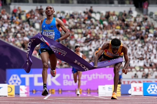 Le Tanzanien Alphonce Felix Simbu, à gauche, remporte la médaille d'or du marathon masculin devant l'Allemand Amanal Petros, qui chute lors des Championnats du monde d'athlétisme à Tokyo, le 15 septembre 2025.