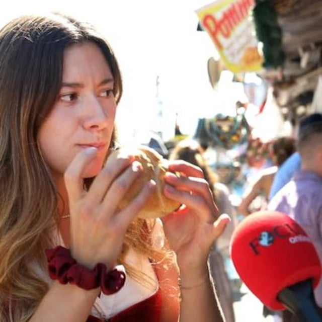 Der Feinkost-Stand vor dem Hacker-Festzelt. Hier wollen Franz und Kathi ihre erste vegane Leberkassemmel auf dem Oktoberfest probieren. Franz macht den Anfang. Seine Reaktion überzeugt Kathi, sich auch eine zu holen.