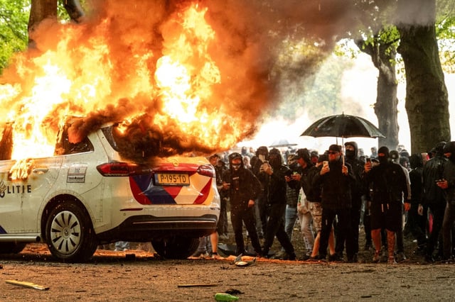 Une voiture de police incendiée lors d'une manifestation anti-immigration à La Haye, aux Pays-Bas, le 20 septembre 2025